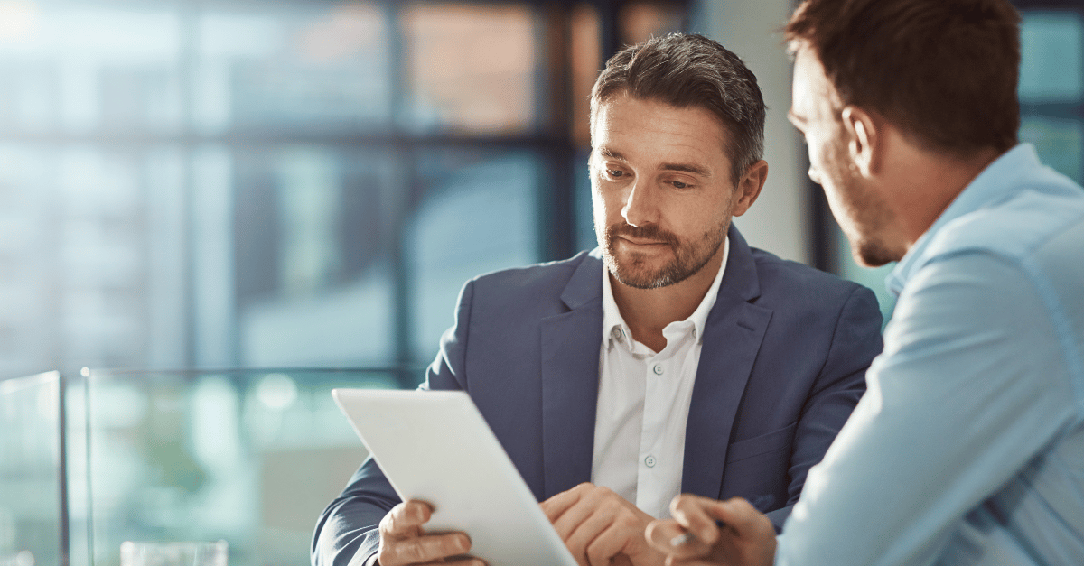 Two men looking at an ipad working